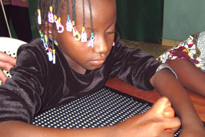A pupil from the Boulsa Centre for the Blind during a Braille writing class.